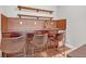 Stylish bar area with custom cabinets, open shelving, and seating for entertaining guests at 21900 E 46Th Pl, Aurora, CO 80019