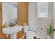 Chic powder room features a pedestal sink, tiled accent wall, and a window for natural light at 21900 E 46Th Pl, Aurora, CO 80019
