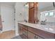 Bathroom with double sinks, dark wood cabinetry, decorative mirror, and walk in shower at 21900 E 46Th Pl, Aurora, CO 80019