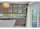 Bright kitchen boasts stainless appliances, glass-front cabinets, tiled backsplash, and natural light, offering a view of the backyard at 21900 E 46Th Pl, Aurora, CO 80019