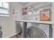 Well-organized laundry room featuring a modern washer and dryer and ample shelving space at 21900 E 46Th Pl, Aurora, CO 80019