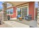 Outdoor patio area showcasing stone columns, comfortable seating, and a view of the backyard at 21900 E 46Th Pl, Aurora, CO 80019