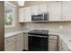 Updated kitchen featuring GE stainless steel microwave and a view through the window at 7767 Elmwood St, Littleton, CO 80125