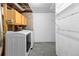 The laundry room has a washer, dryer, cabinetry, and shelving at 7767 Elmwood St, Littleton, CO 80125