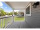 Inviting covered porch with white railing offers a tranquil outdoor space with views of the tree-lined street at 7767 Elmwood St, Littleton, CO 80125