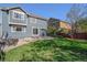 A beautiful backyard featuring a green lawn, a patio with a fire pit, and a seating area at 10647 Nucla St, Commerce City, CO 80022