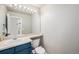 Cozy powder room featuring a blue vanity, a sink, and a toilet, designed for convenience and functionality at 10647 Nucla St, Commerce City, CO 80022