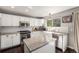 Bright kitchen with white cabinets, stainless steel appliances, granite countertops and farmhouse sink at 10647 Nucla St, Commerce City, CO 80022