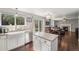 Spacious kitchen with a view of the dining area, featuring white cabinets, stainless steel appliances, and a granite island at 10647 Nucla St, Commerce City, CO 80022