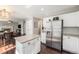 Open kitchen layout with a central island, stainless steel refrigerator, and view to the dining and living areas at 10647 Nucla St, Commerce City, CO 80022