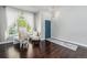 Cozy living room features beautiful hardwood floors and a bright blue entry door at 10647 Nucla St, Commerce City, CO 80022