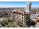 Low-rise building with brick and tile roof, with cityscape and mountain views beyond at 99 S Downing St # 605, Denver, CO 80209