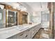 Spa-like bathroom with double sinks, granite counters, custom wood trim, and a glass-enclosed shower at 99 S Downing St # 605, Denver, CO 80209