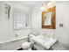 Bright bathroom with a pedestal sink, wood-framed mirror, and a classic white color scheme at 99 S Downing St # 605, Denver, CO 80209