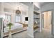 Bright bedroom with modern chandelier, chic decor, built in shelves, and large windows with plantation shutters at 99 S Downing St # 605, Denver, CO 80209