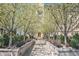 Apartment building entrance with sidewalk framed by flowering trees and manicured landscaping at 99 S Downing St # 605, Denver, CO 80209