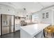 White kitchen features marble countertops, stainless steel appliances, and herringbone floors at 99 S Downing St # 605, Denver, CO 80209