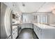 Bright white kitchen with herringbone floors, stainless steel appliances, and marble countertops at 99 S Downing St # 605, Denver, CO 80209