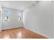Bright bedroom featuring hardwood floors, two windows, and freshly painted walls at 1100 Urban St, Lakewood, CO 80401