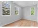 Bedroom with hardwood floors featuring three large windows providing ample natural light at 1100 Urban St, Lakewood, CO 80401