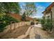 An outdoor space with a stone retaining wall, rock ground cover, and mature landscaping at 2807 S Nelson St, Lakewood, CO 80227