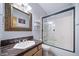 Well-lit bathroom featuring a granite-topped sink vanity and a shower with a glass enclosure at 2807 S Nelson St, Lakewood, CO 80227