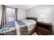 A cozy bedroom featuring a queen-sized bed, window, and dark wood night stand at 2807 S Nelson St, Lakewood, CO 80227