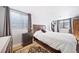 Bedroom with light colored bedding, wood floors, and a view of the outside window well at 2807 S Nelson St, Lakewood, CO 80227