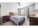 Cozy bedroom filled with natural light, complete with a window, dresser, bedside table, and ceiling fan at 2807 S Nelson St, Lakewood, CO 80227