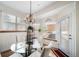 Sun-filled dining area with glass table, white chairs, and a charming chandelier for a cozy meal at 2807 S Nelson St, Lakewood, CO 80227