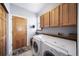 Bright laundry room with upper cabinets, a washer, and a dryer with folding space at 2807 S Nelson St, Lakewood, CO 80227