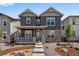 Charming two-story home with gray siding, stone accents, and a cozy front porch at 24851 E 33Rd Dr, Aurora, CO 80019