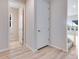 Bright hallway with light wood floors, white doors, and neutral paint creates a welcoming transition space at 24851 E 33Rd Dr, Aurora, CO 80019