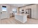 Bright open kitchen with stainless appliances, white cabinets, island, and a door to the outside at 24851 E 33Rd Dr, Aurora, CO 80019