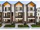 Contemporary townhome exterior with black accents, balconies, and well-manicured landscaping at 8240 E 36Th Ave # 33, Denver, CO 80238