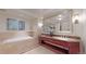 Elegant bathroom features a soaking tub, double vanity and neutral stone tile at 1891 Curtis St # 1613, Denver, CO 80202
