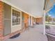 Inviting covered front porch featuring brick accents, seating, and a charming entrance at 3790 E Geddes Ave, Centennial, CO 80122