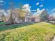 Well-maintained front yard featuring lush green grass and mature trees framing the property under a sunny sky at 3790 E Geddes Ave, Centennial, CO 80122