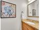 Stylish half bath with granite countertop, wooden vanity, decorative mirror, and elegant floral artwork at 3790 E Geddes Ave, Centennial, CO 80122
