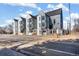 Street view of modern townhomes featuring gray and white exteriors and fenced front patios at 5375 W 14Th Ave, Lakewood, CO 80214