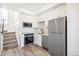 Modern kitchen with stainless appliances, white cabinets and a tiled backsplash at 5375 W 14Th Ave, Lakewood, CO 80214