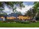 Picturesque backyard featuring a stone patio, outdoor seating, a fire pit, and lush green lawn at 15 South Ln, Cherry Hills Village, CO 80113