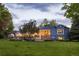Expansive backyard with a stone patio, covered porch, and lush lawn, perfect for outdoor entertaining and relaxation at 15 South Ln, Cherry Hills Village, CO 80113