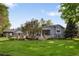 Manicured backyard with patio, green lawn and mature trees create a serene outdoor living space at 15 South Ln, Cherry Hills Village, CO 80113