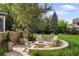 Backyard fire pit with seating nestled in a lush lawn and verdant landscaping at 15 South Ln, Cherry Hills Village, CO 80113