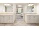 Dual vanity bathroom with a tiled floor, separate sinks, and a view into a cozy living room at 15 South Ln, Cherry Hills Village, CO 80113