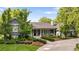 Beautiful home with lush landscaping and a winding driveway, surrounded by mature trees and green grass at 15 South Ln, Cherry Hills Village, CO 80113