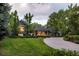 Beautiful home with lush landscaping and a winding driveway, surrounded by mature trees and green grass at 15 South Ln, Cherry Hills Village, CO 80113