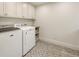 Modern laundry room with patterned tile flooring, cabinetry, and new front load appliances at 15 South Ln, Cherry Hills Village, CO 80113