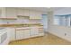 Cozy kitchen featuring white cabinets and appliances, with a double sink at 14390 E Marina Dr # 601, Aurora, CO 80014